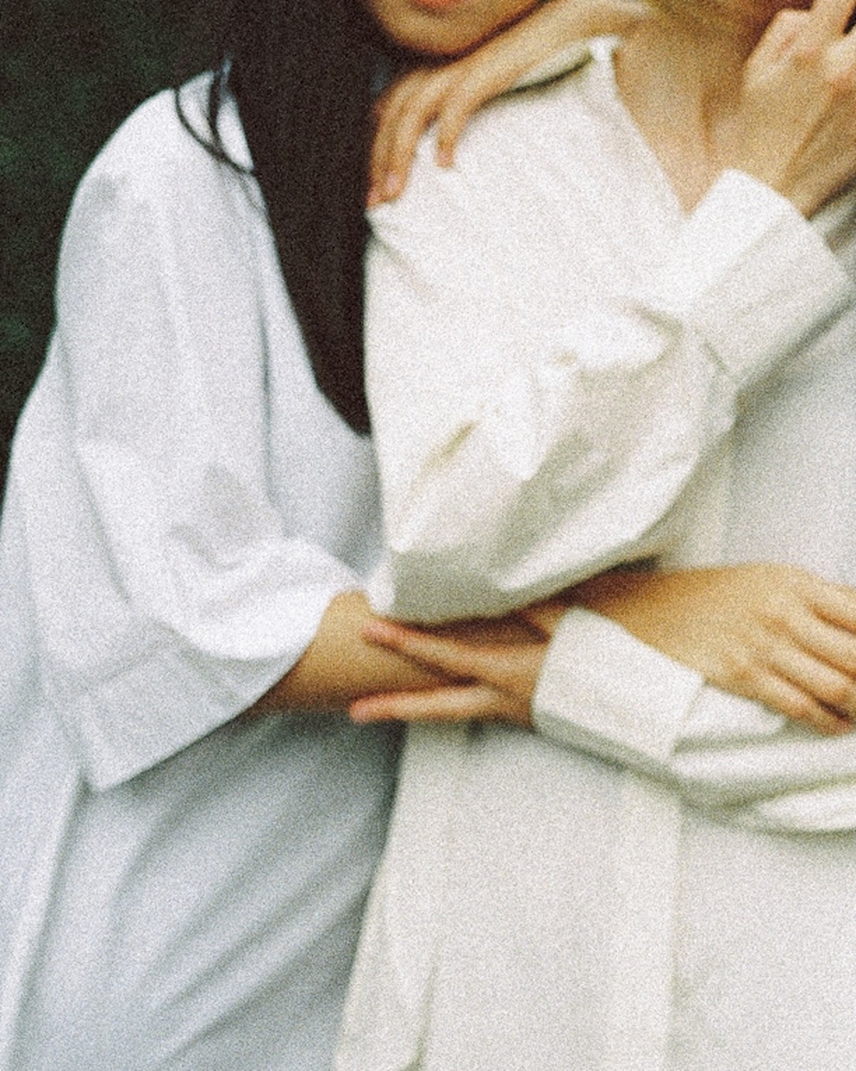 Two women standing close together, arms linked.