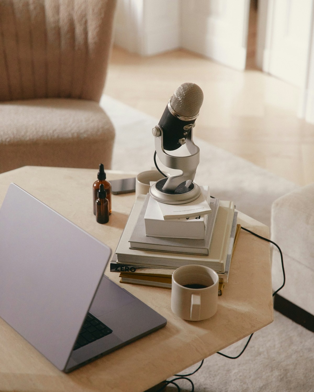 A low table with a laptop, a microphone and a half-drunk coffee.