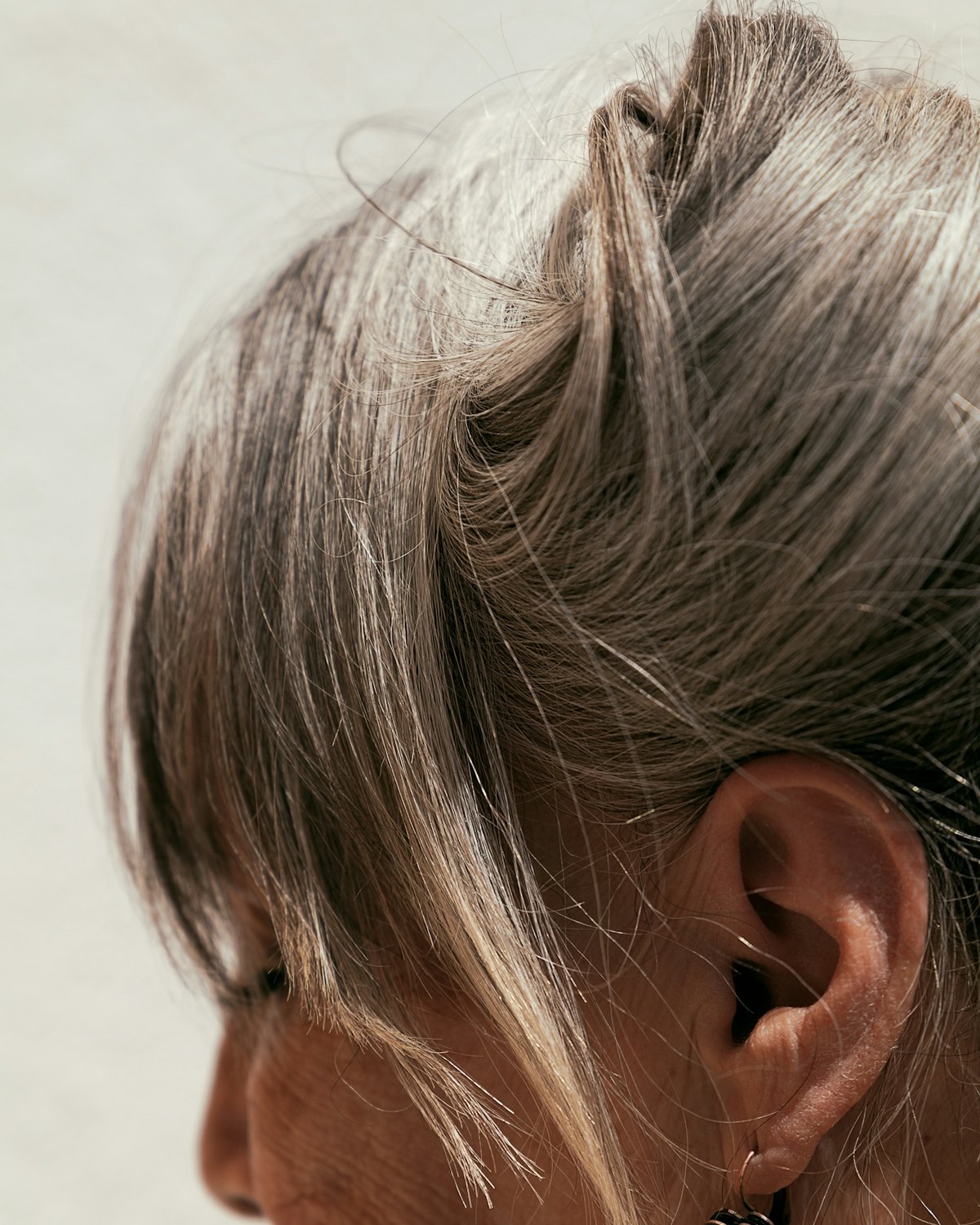 A woman in profile, hair loosely pinned up.